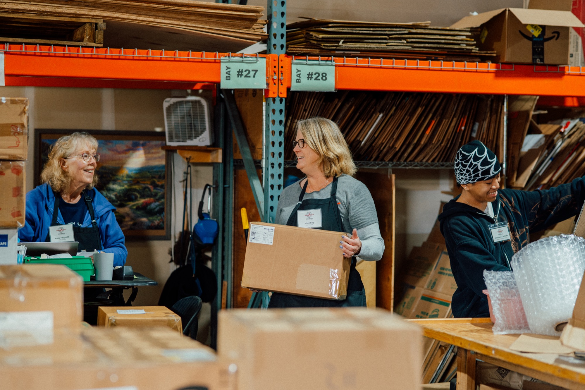 Volunteers sorting and carrying boxes of medical supplies in the MMI warehouse