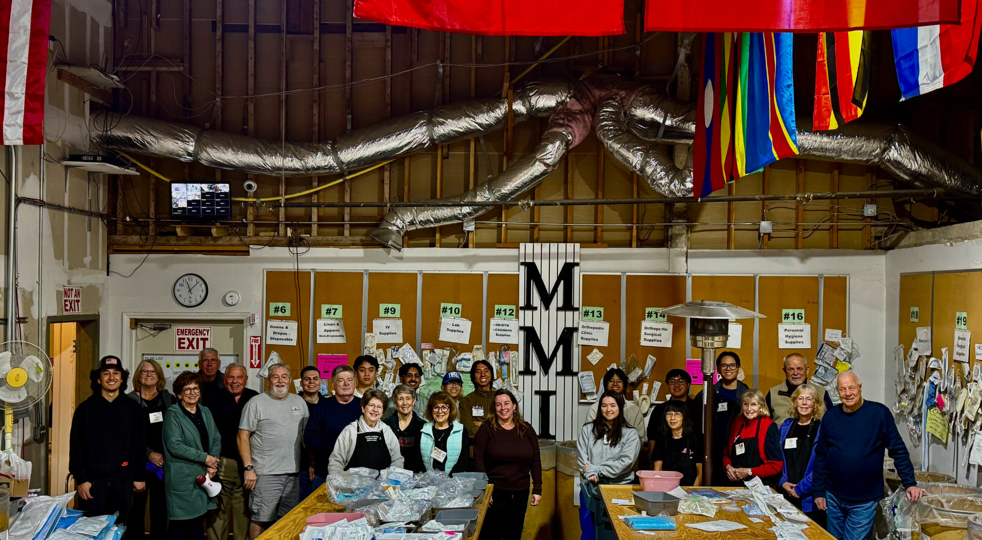 MMI volunteers gathered beneath the warehouse letters after sorting donated medical supplies